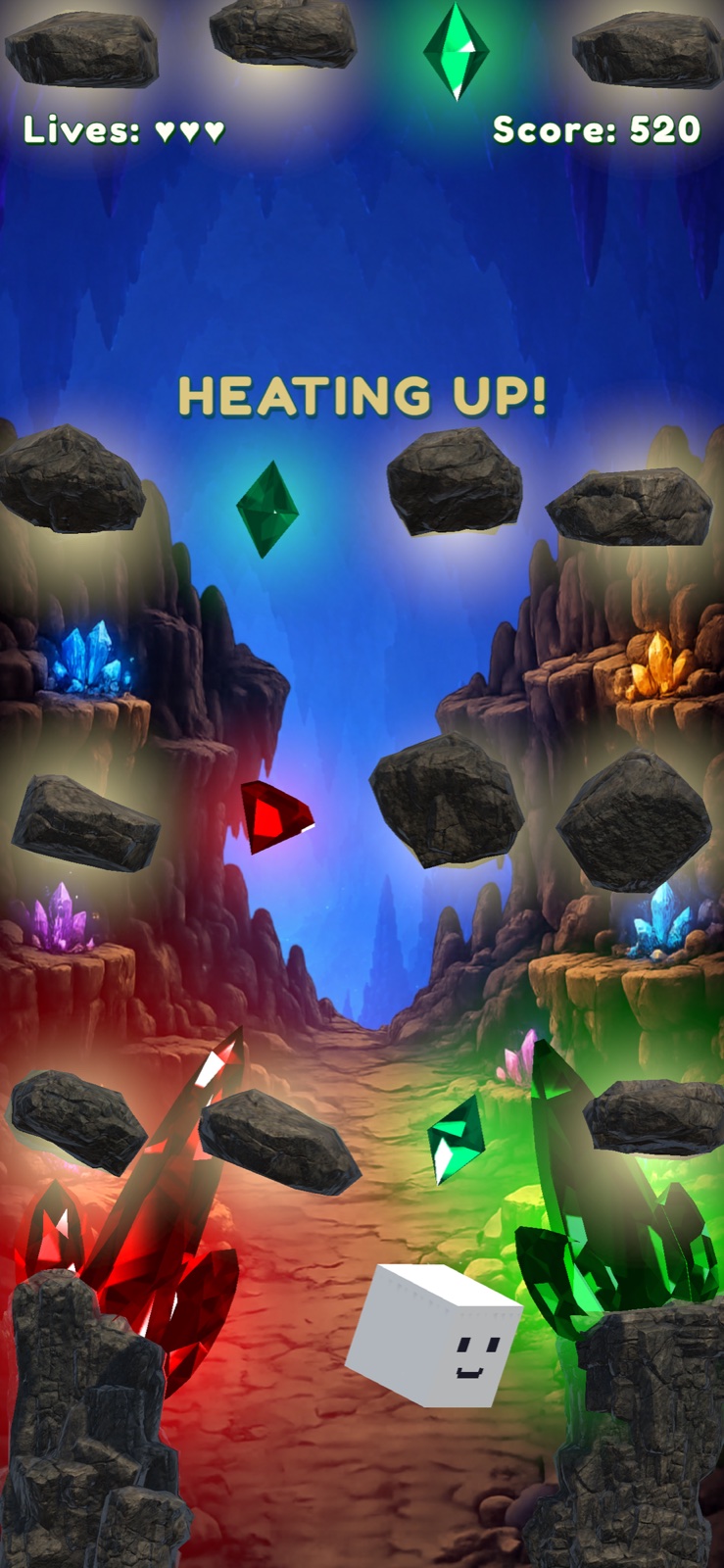 Gem Catch Rush gameplay in Crystal Cave with falling rocks, green and red gems, three lives, and a Heating Up message